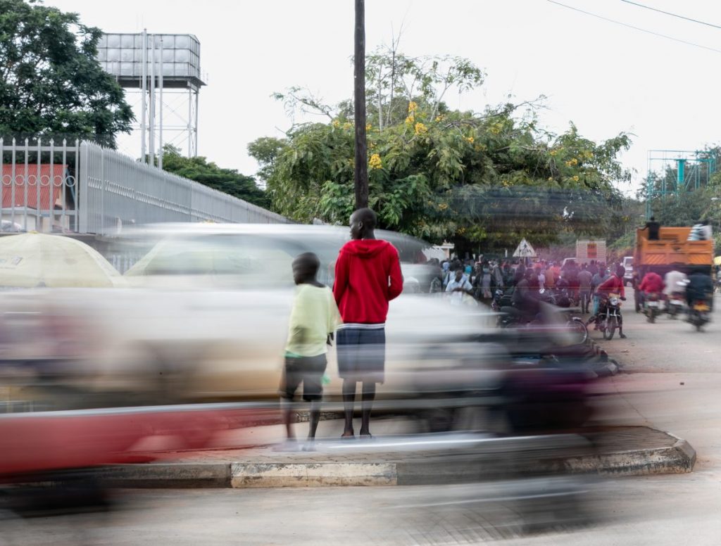Two children crossing a busy main road in Africa reflecting climate change
