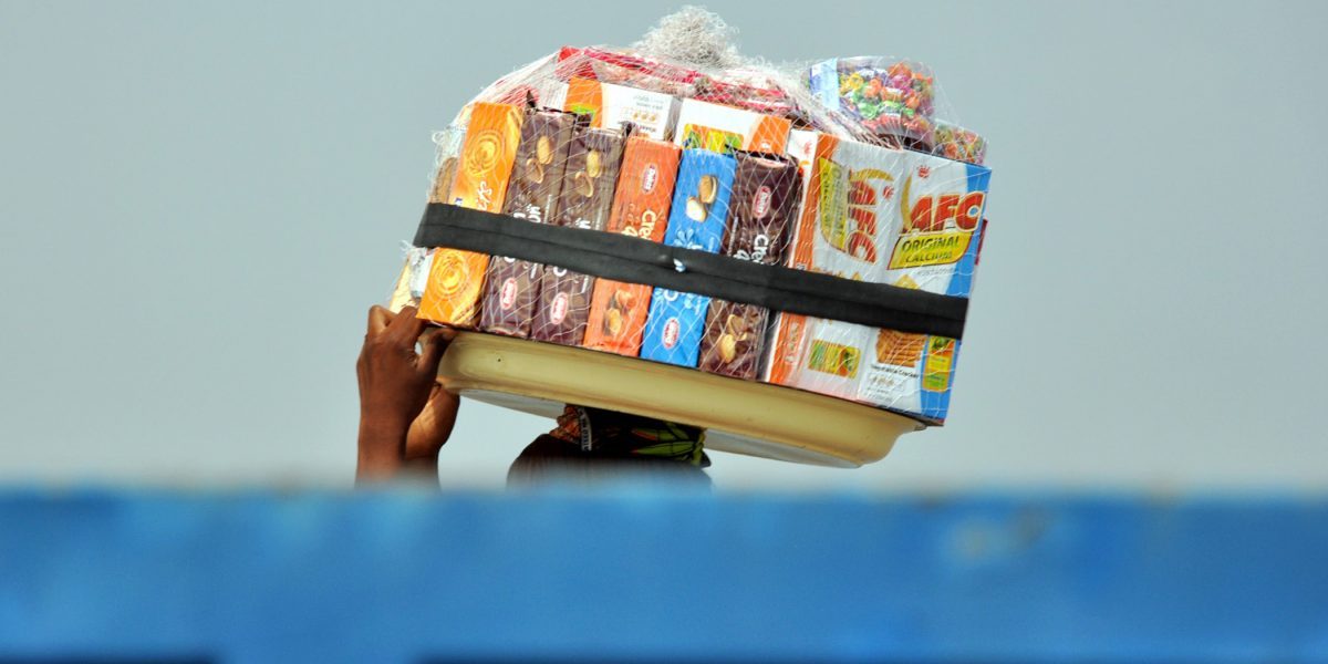 A woman trader crosses the busy Ancien Pont Bridge in Cotonou, Republic of Benin. Image: Getty, Martin Reilly