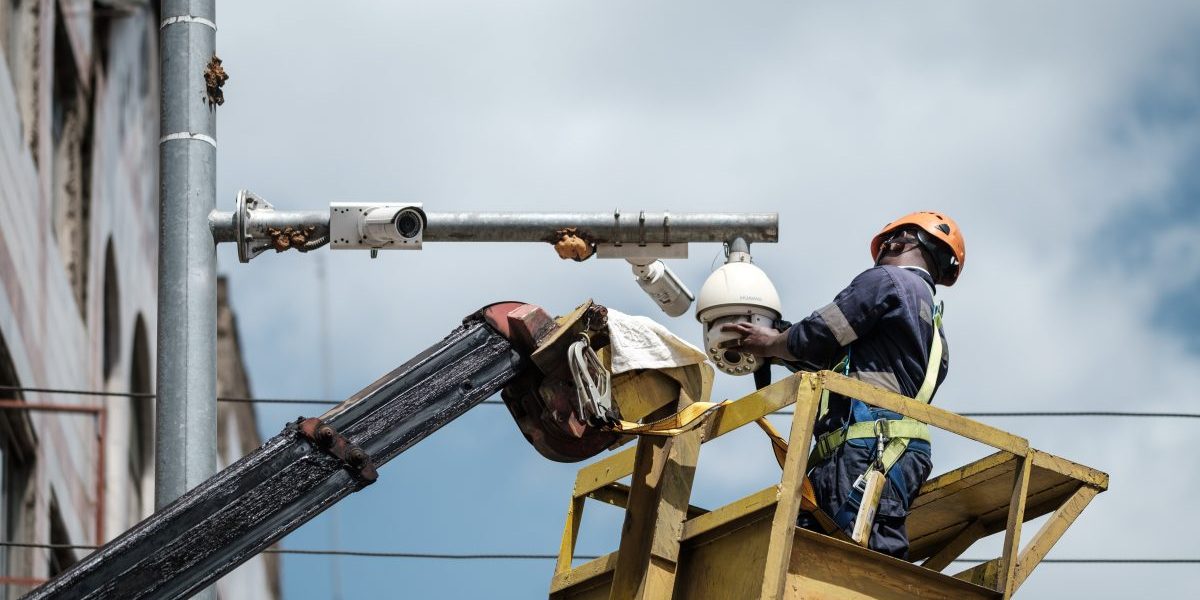 A worker cleans a surveillance camera on a street in Nairobi, on January 18, 2019. Image: Getty, Yasuyoshi Chiba/AFP
