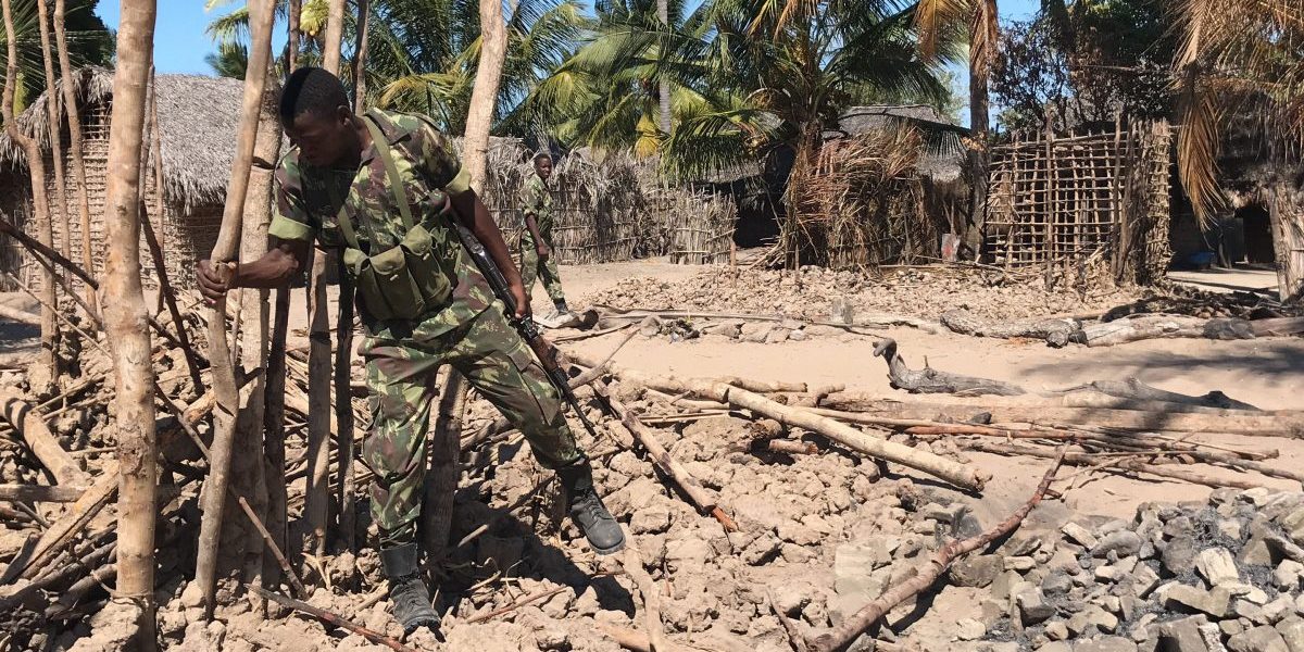 Mozambican Army soldiers bring down a structure torched by attackers, to be rebuilt as shelter for people fleeing the recent attacks, in Naunde, northern Mozambique, on June 13, 2018. Image: Getty, Joaquim Nhamirre/AFP