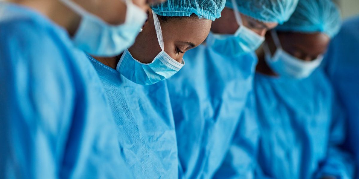 Group of surgeons performing a medical procedure in an operating room. Image: Getty, PeopleImages