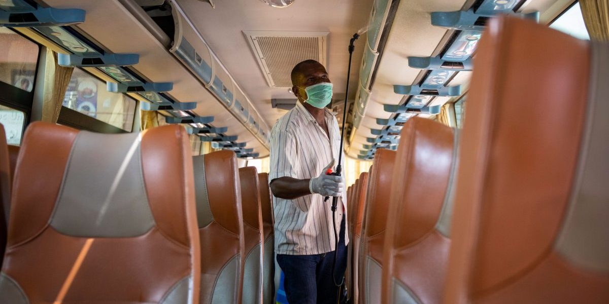 An intercity bus company employee disinfects the bus as a preventive measure against the spread of 
COVID-19 in Kampala, Uganda. Image: Getty, Badru Katumba/AFP
