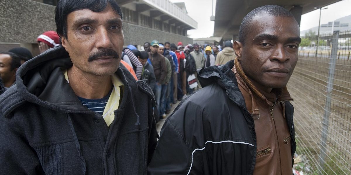 Hundreds of refugees queue outside the South African Department of Home Affairs to apply for extensions of their asylum seeker permits, in Cape Town. Image: Getty Images, Rodger Bosch/AFP