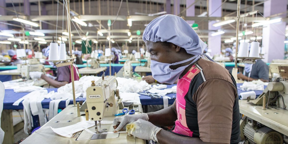 A man uses a sewing machine to assemble a piece of personal protective equipment for COVID-19 coronavirus frontline health workers at a factory commissioned by the government, in Accra, on April 17, 2020. Image: Getty, Nipah Dennis/AFP