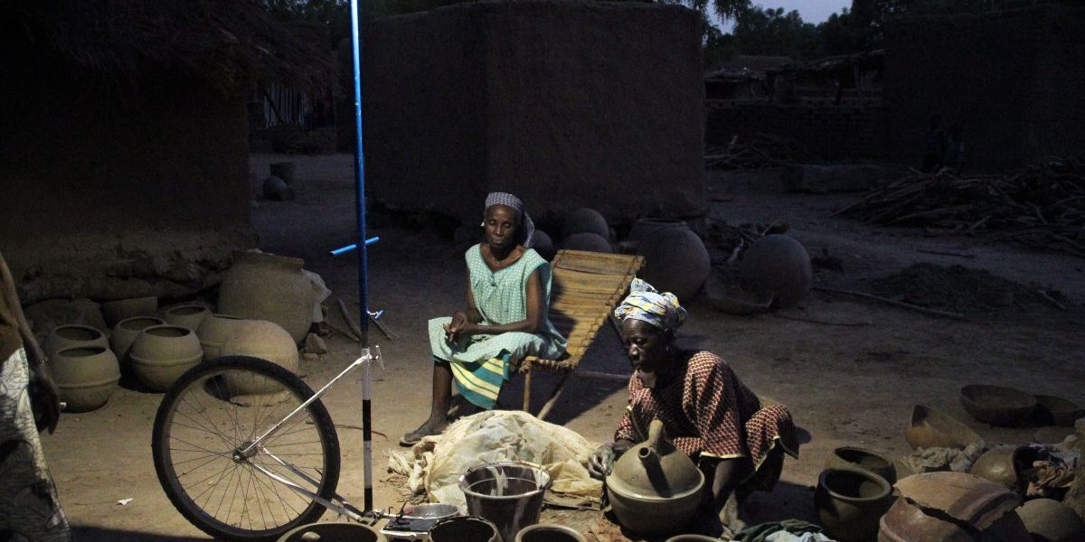 Bamako, 2014: Women make ‘canari’, a small spherical jar, under a mobile solar-powered streetlamp. Image: Getty, Habibou Kouyate/AFP