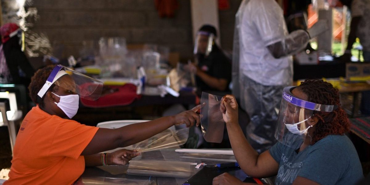 Members of a youth group comprised of some entrepreneurs who have lost their livelihoods due to the economic slump caused by countrywide restrictions imposed on movement of people and goods, in a bid to curb the spread of the COVID-19 coronavirus, manufacture hand-made personal protective equipment (PPE) at a shed in Waithaka, a suburb of Nairobi. Image: Getty, Tony Karumba