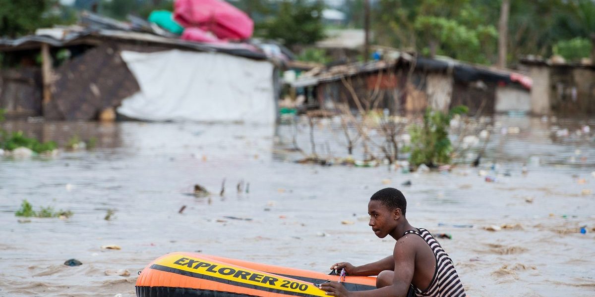 A man uses a rubber dinghy to navigate through the flooded Jangwani neighbourhood in Dar es Salaam, Tanzania. Image: Getty, Daniel Hayduk/AFP
