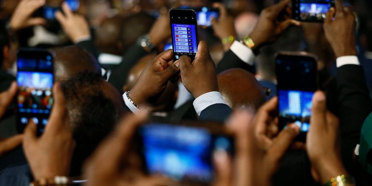 People take pictures with mobile phones during the formal announcement of the National and Provincial
Election Results at the Independent Electoral Commission (IEC) Results Operations Centre on 11 May 2019
in Pretoria, South Africa. Image: Getty, Phill Magakoe/AFP