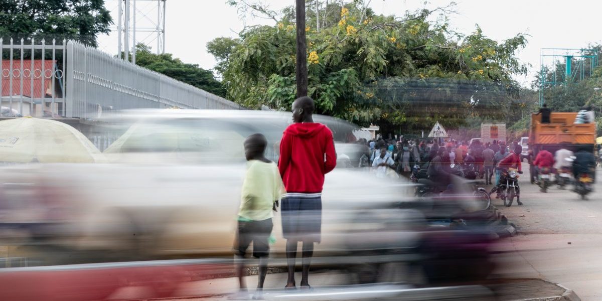 Two children crossing a busy main road in Africa reflecting climate change