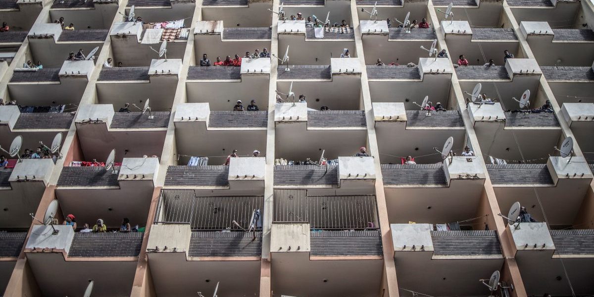 Residents of a Hillbrow, Johannesburg, building observe from the balconies on March 28, 2020 as a police operation is conducted to make sure everyone observes the Country's lockdown, South Africa. Image, Getty, Marco Longari/Contributor